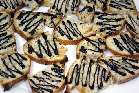 A tapa of rustic bread drizzled with dark chocolate, olive oil, and sea salt.