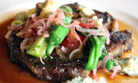 A big, juicy rib eye crowned with summer veggies and blue cheese.