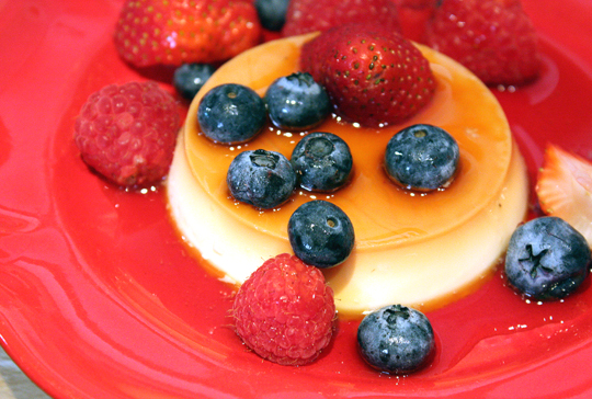 Panna cotta with caramel syrup and fresh berries.