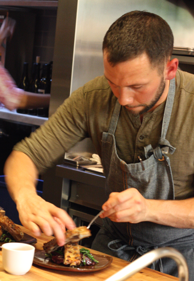 A cook plating up ribs.