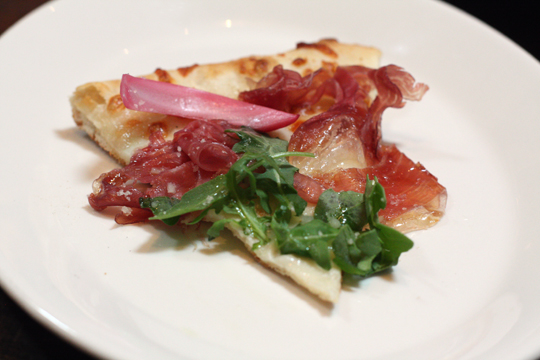 A slice of speck and argula pizza.