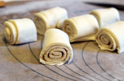 Purchased puff-pastry is thawed, then rolled up jelly roll-style before being sliced into six equal portions.