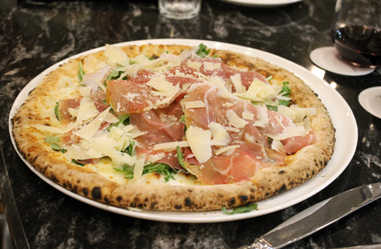 Pizza with prosciutto and arugula.