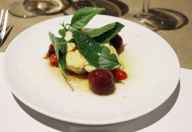Tofu "burrata'' with dry-farmed tomatoes, Thai basil and olive oil.