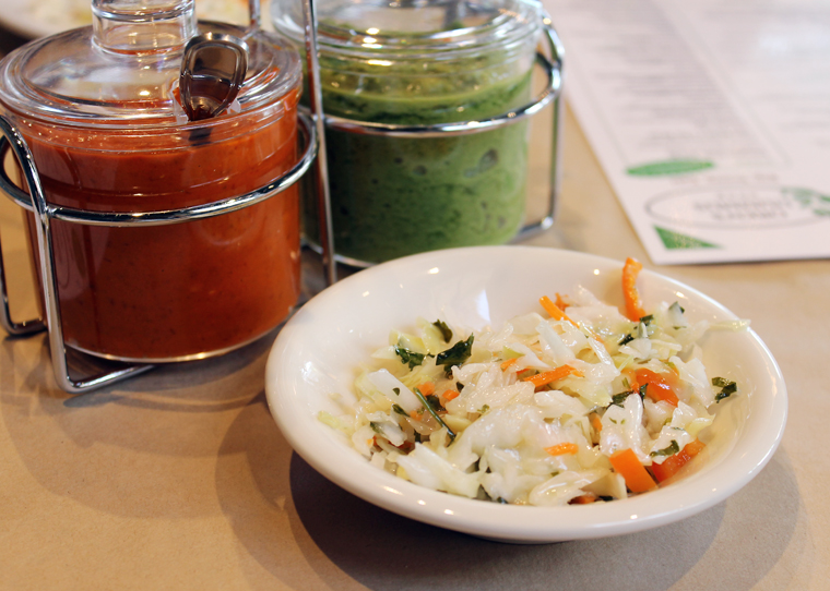 Complimentary slaw, and house-made hot sauces (the green one is hotter).