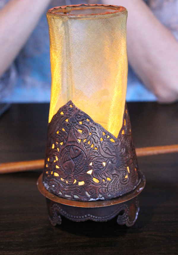A candle illuminates each table.