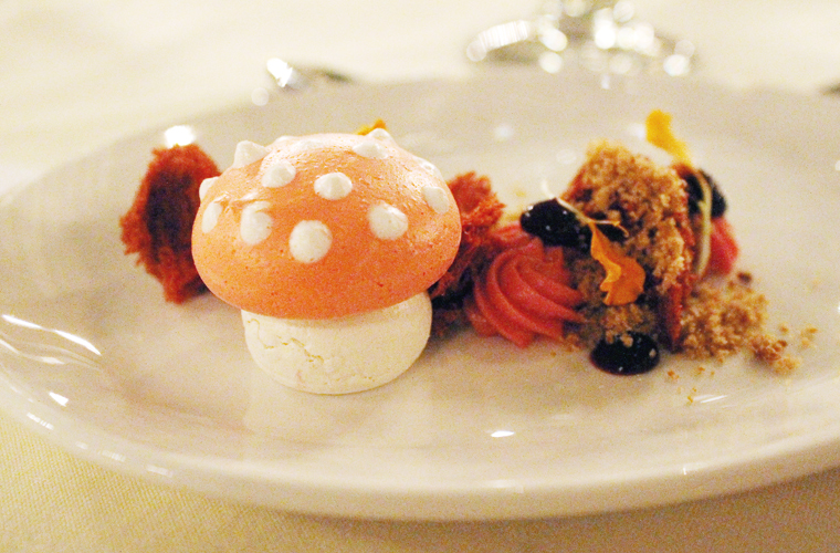 A cute meringue mushroom is the centerpiece of this dessert.