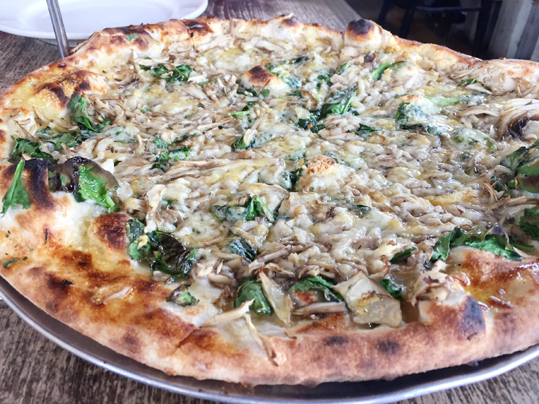 A generous amount of hen of the woods mushrooms cover this incredible pizza. 