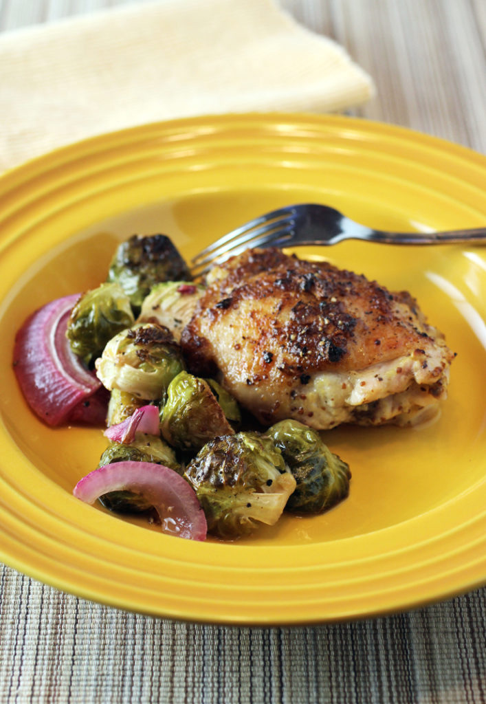 Honey-mustard chicken, charred Brussels sprouts, and sweet red onions -- all roasted in one pan for ease.
