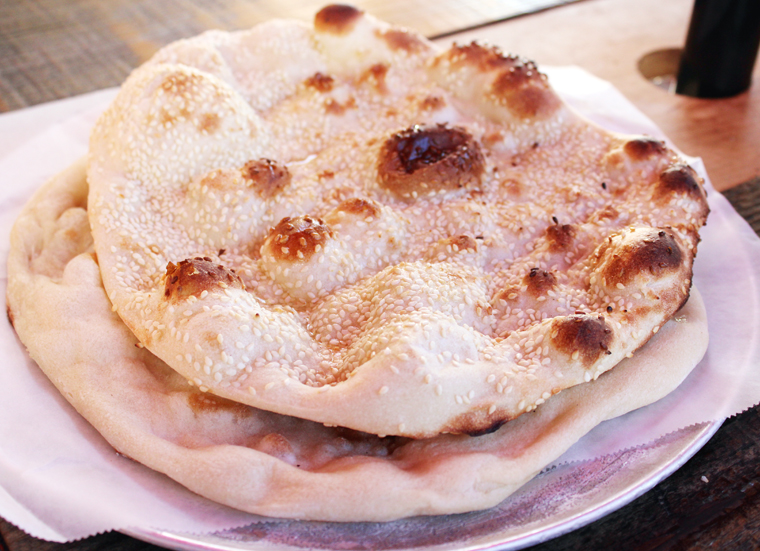 Full-sized sesame naan (on top) and regular naan (underneath).