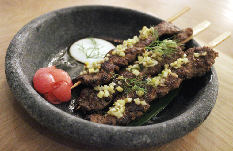 Lamb skewers cooked on a hot stone.