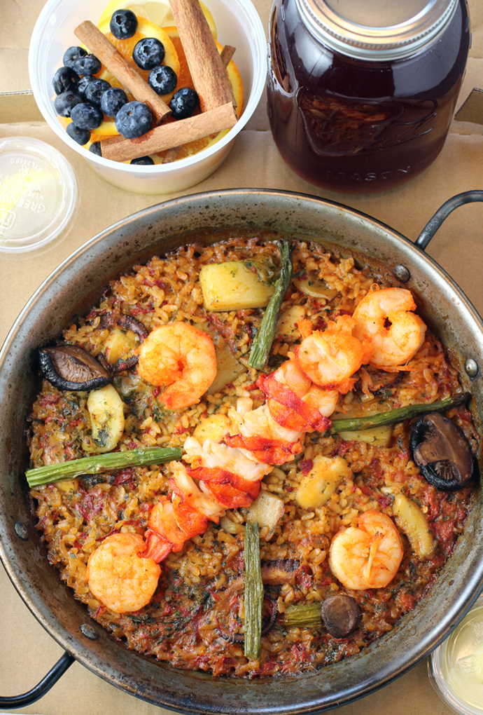 The restaurant's cooked, ready-to-eat lobster paella, packed to take home, along with sangria and garnishes.