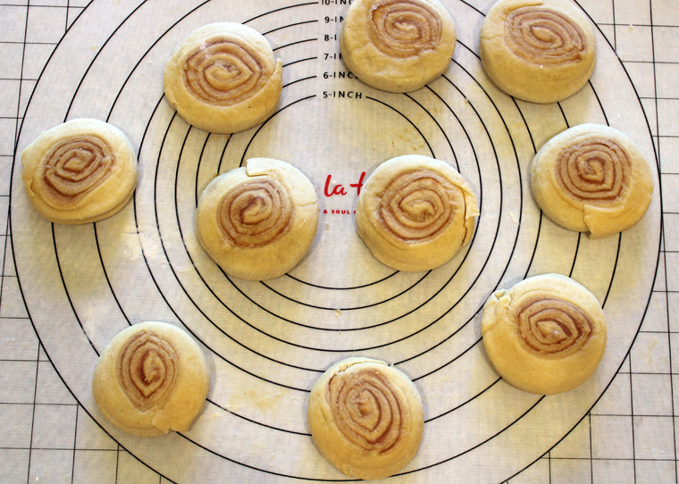 The dough is rolled up, then sliced. Each slice is then flattened slightly.