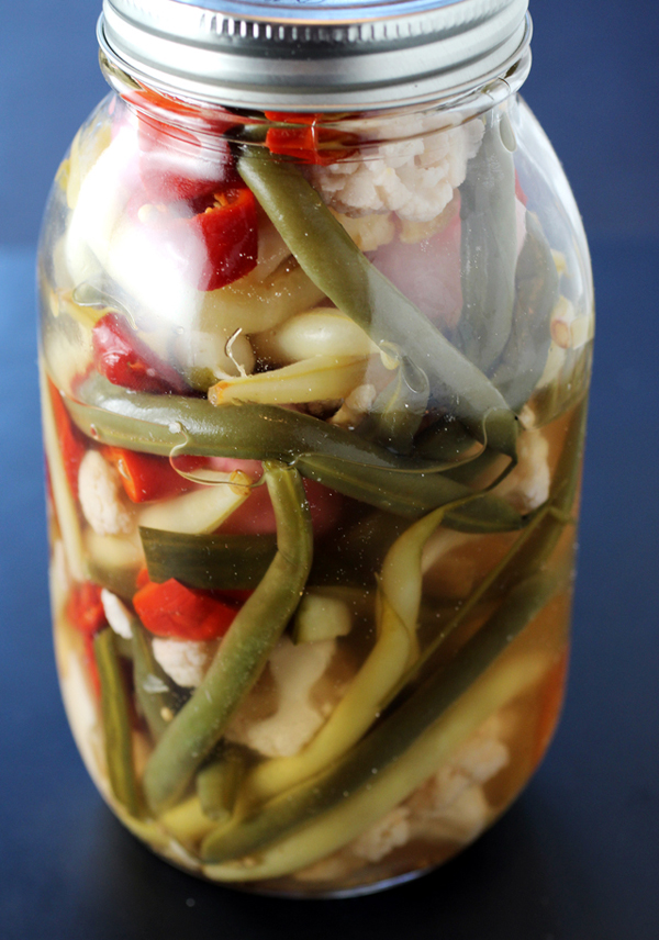 A jar of assorted pickled veggies.