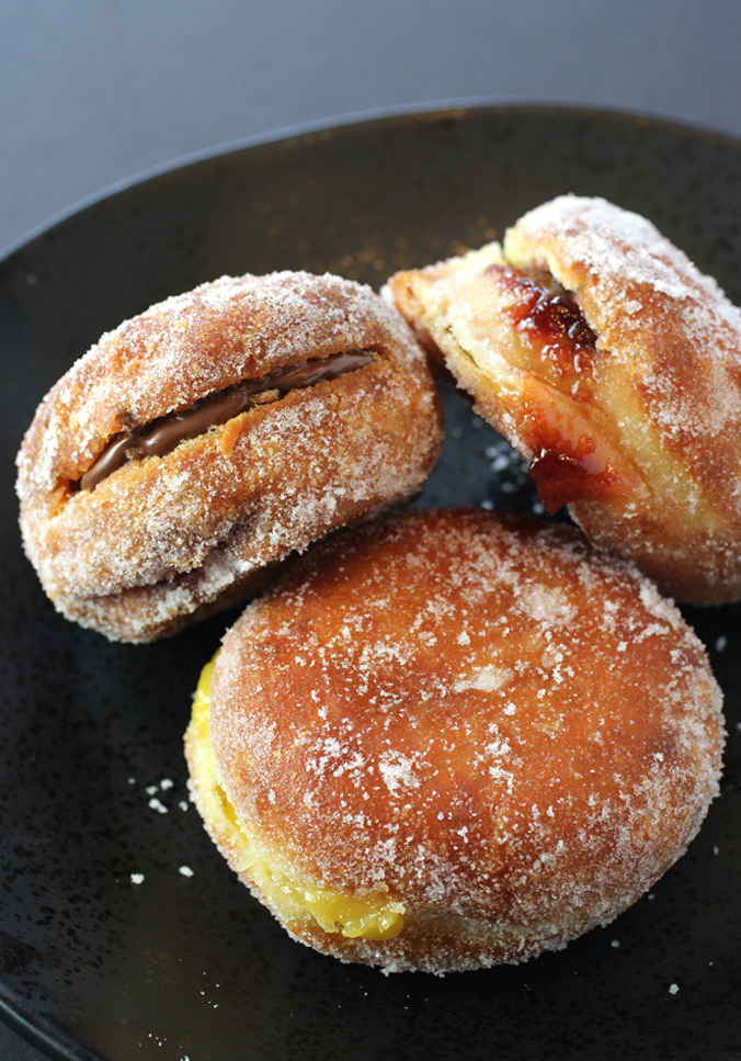 Sugar-dusted, filled Portuguese donuts.