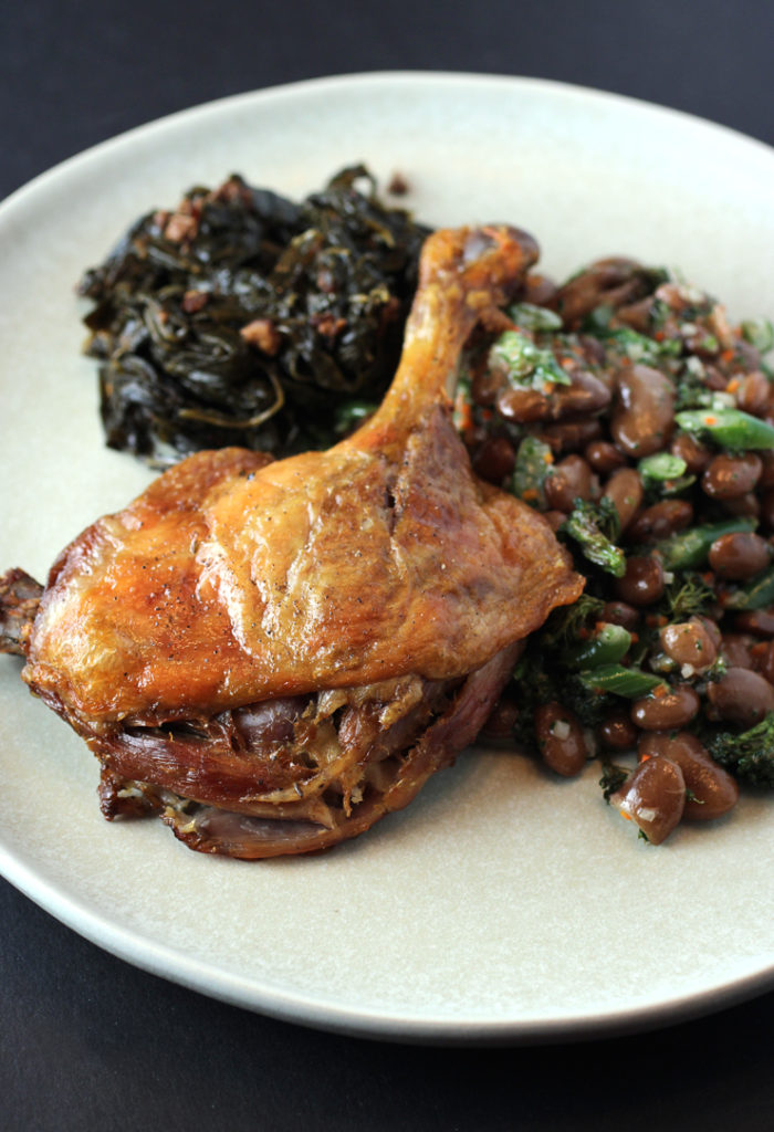 Duck leg confit with braised greens, and garlicky beans from Michelin-starred Protege.