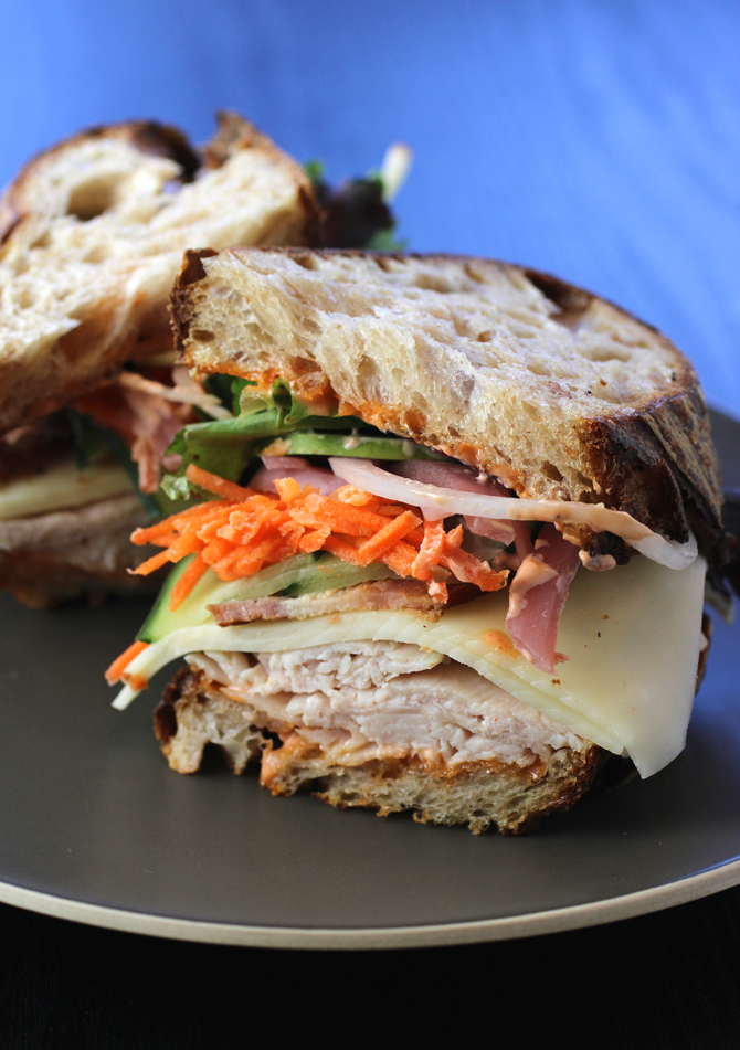 A satisfying turkey sandwich with a load of fresh veggies inside.