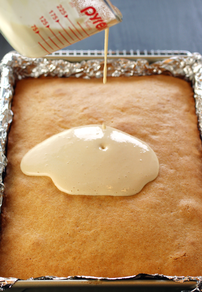 Pouring the preserved lemon topping over the warm cake.