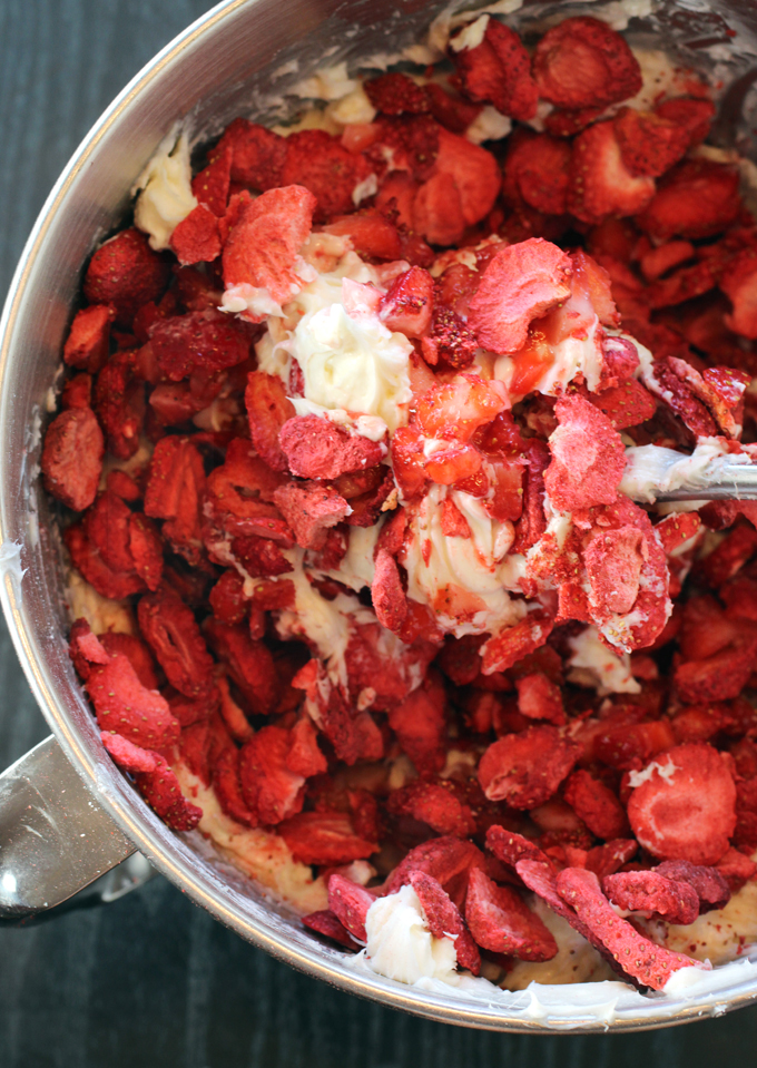 Mixing the fresh and freeze-dried strawberries into the cream cheese frosting.