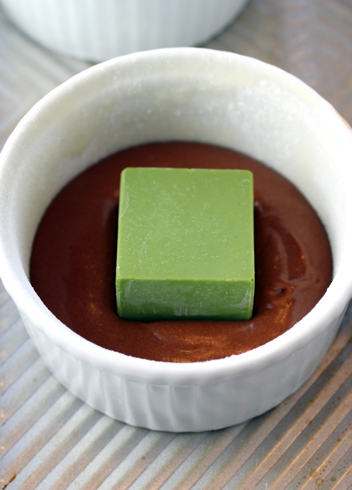One frozen cube gets placed inside each ramekin, then covered with the chocolate cake batter.