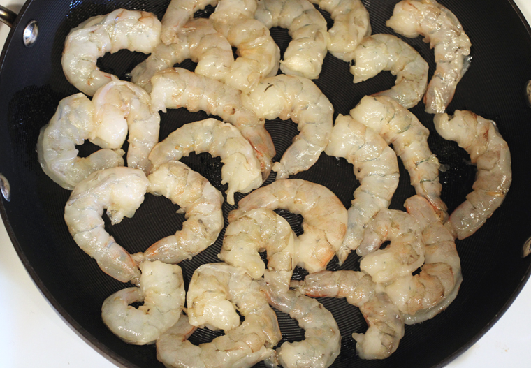 Before you turn on the stovetop, arrange the raw shrimp in one layer in your nonstick pan.