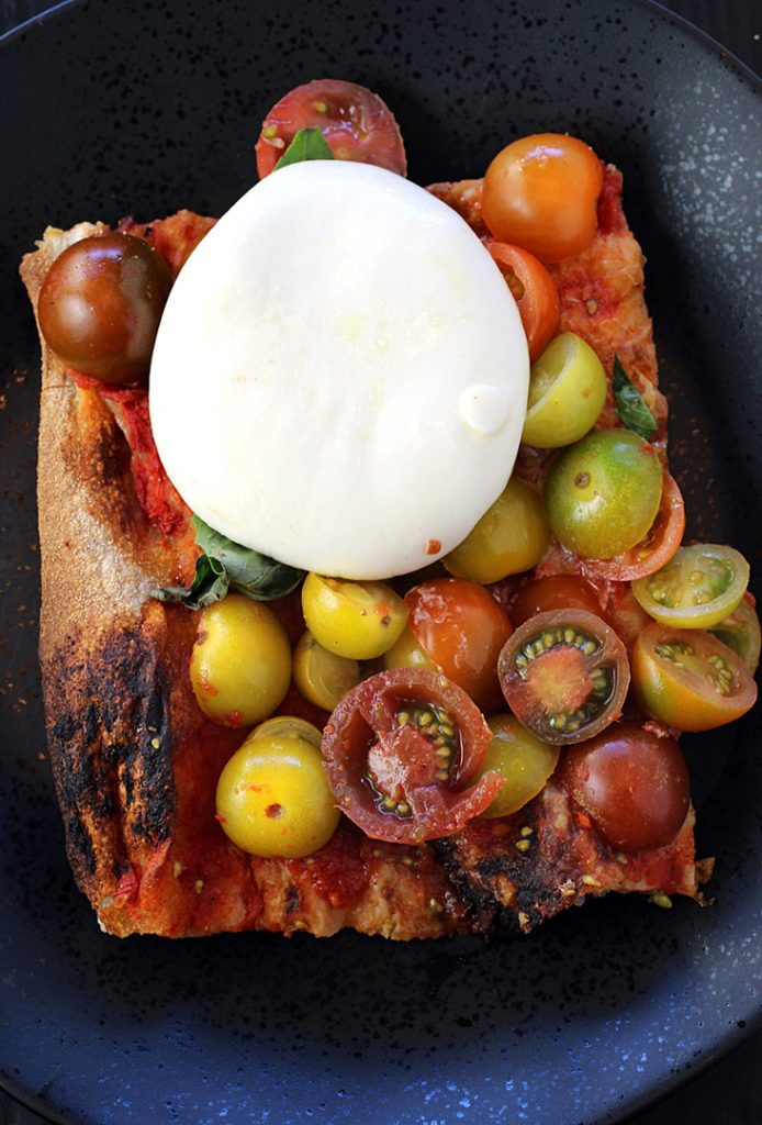 A whole ball of burrata atop Roman-style pizza at Eataly.