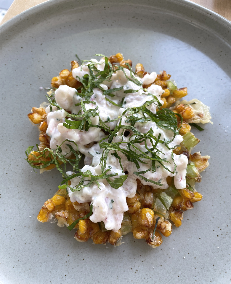 Crispy corn and celery fritter with shrimp salad on top.