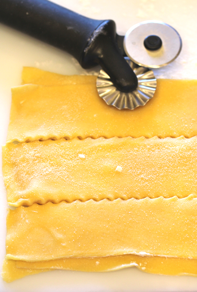Cutting the rolled pasta dough into pappardelle.