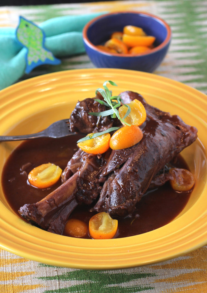 Fall-off-the-bone tender lamb shanks get garnished with wine-simmered, sweet-tangy kumquats.