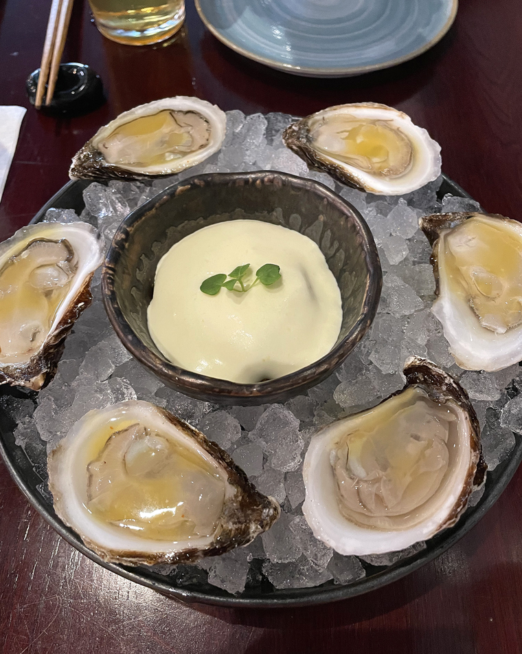A half dozen Black Magic oysters with the Fort Bragg uni preparation in the center of the bowl of ice.