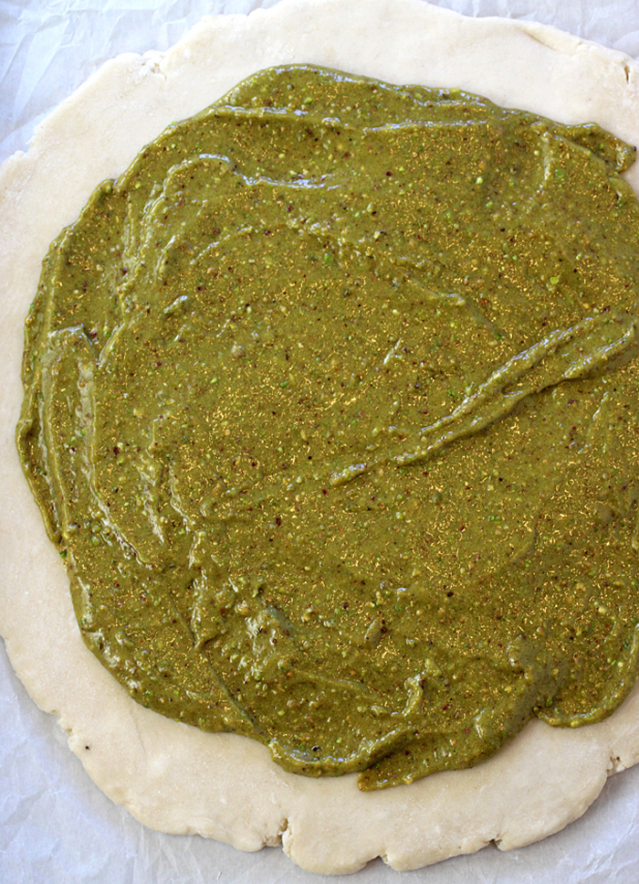 The pistachio paste gets spread on the dough.