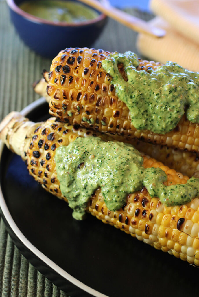 Grilled corn on the cob served with a dazzling tahini chimichurri sauce.