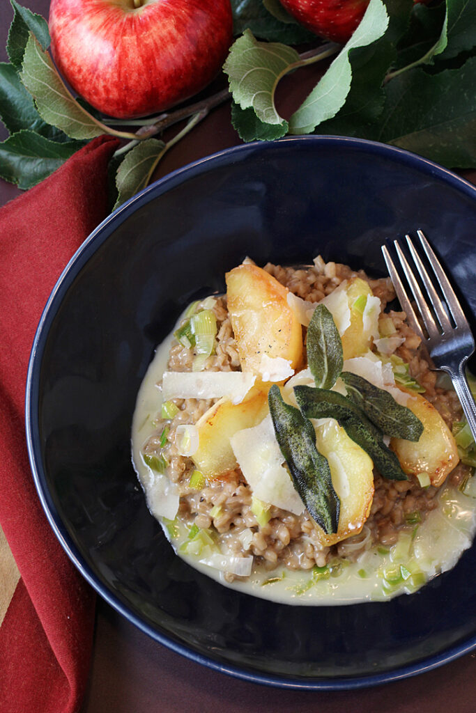 Caramelized Pazazz apple slices top this hearty, warming barley risotto with a velvety leek butter sauce.