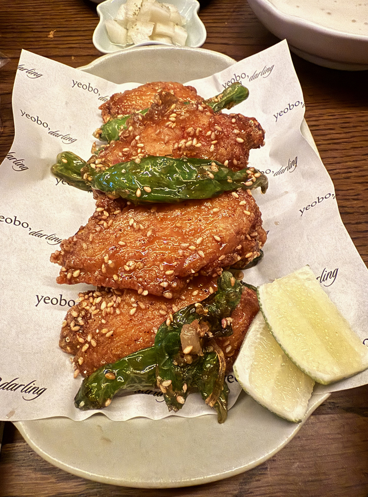 Chicken wings with shishito peppers.