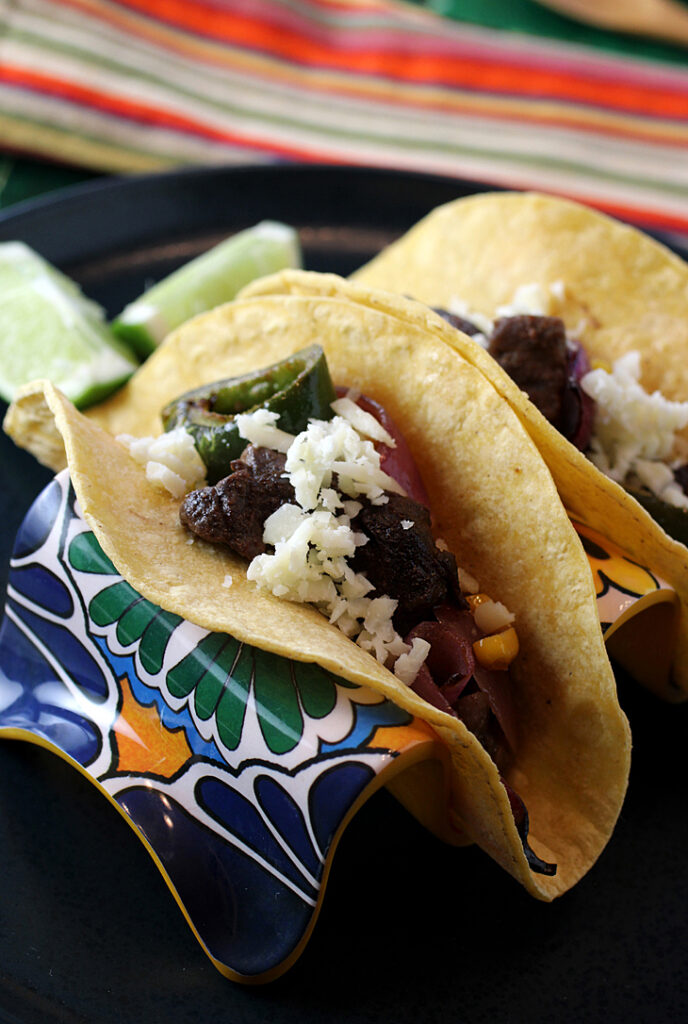 Skirt steak and veggies cook all together on a sheet pan for tacos in a flash.