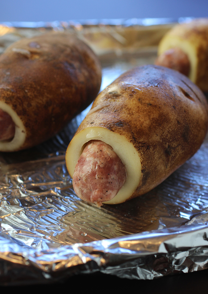Carve out a tunnel inside each potato, then insert a whole sausage.