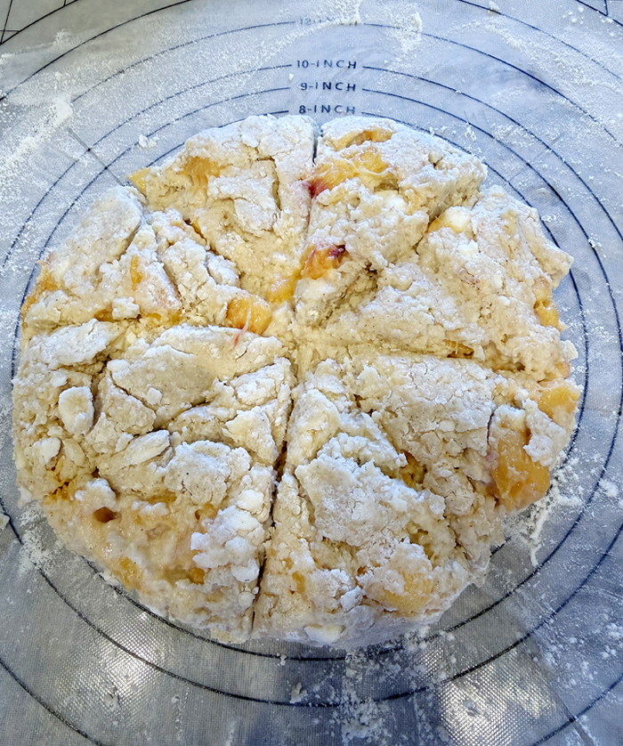 The sticky, shaggy dough gets patted into a round before being sliced.