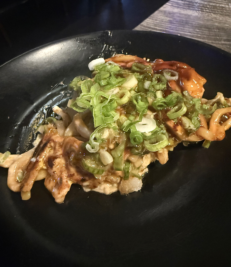Helping myself to a slab of the pork-green onion okonomiyaki with noodles.