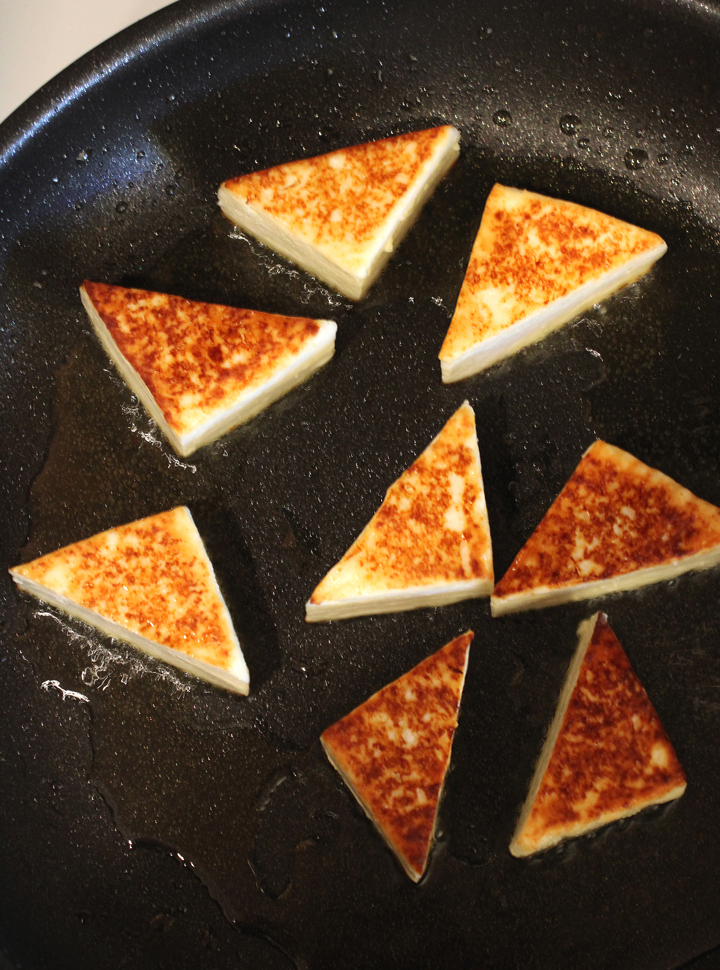 Searing the paneer in a pan.