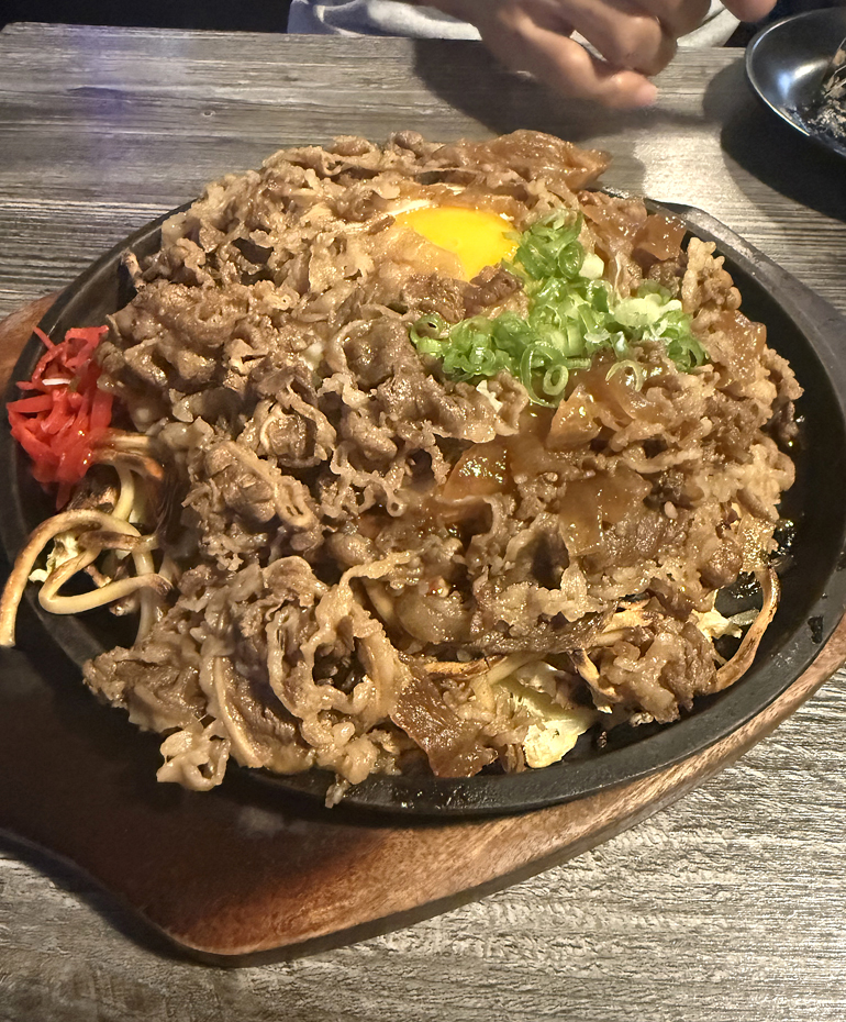 Stewed beef and egg okonomiyaki with added noodles.