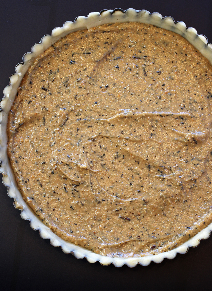The unbaked tart with frangipane spread on top.