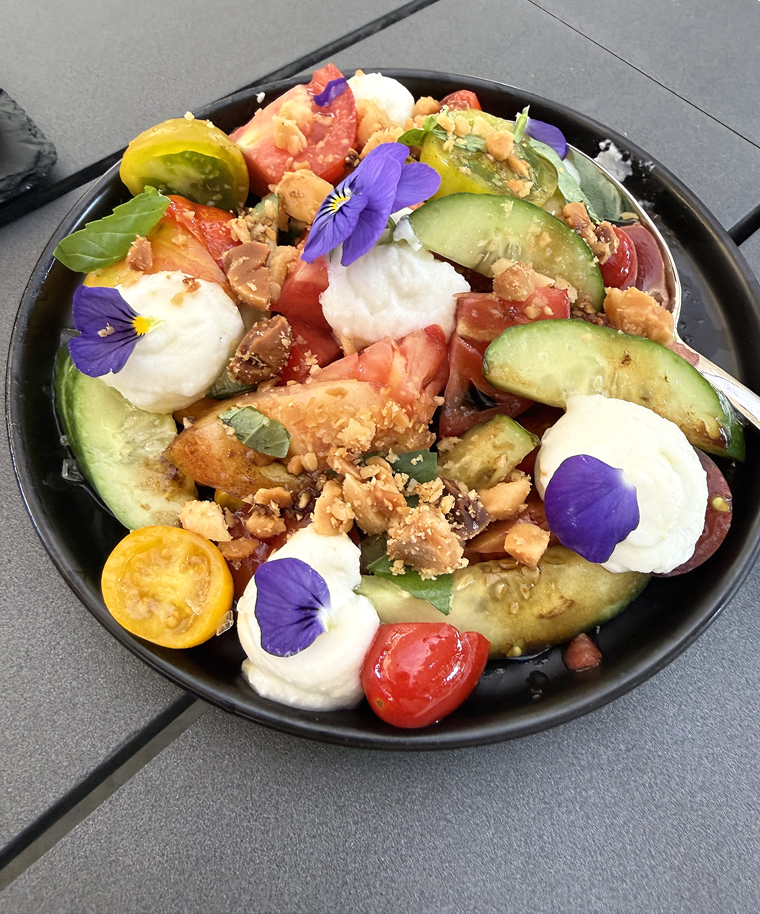 Fresh flowers adorn the tomato and burrata salad.